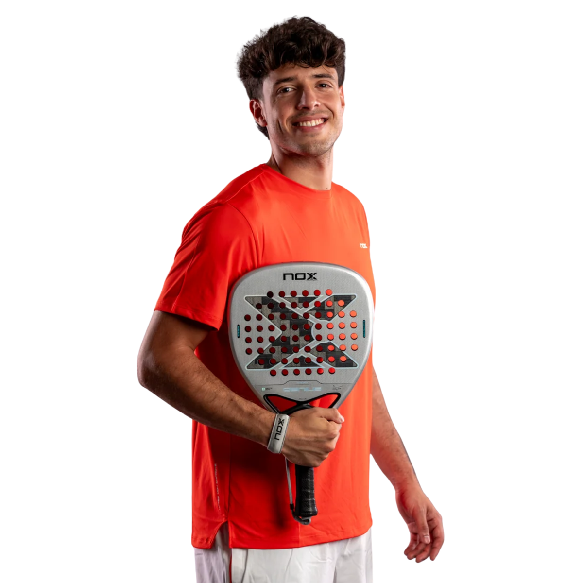 Agustín Tapia holding the NOX Genius Attack 12K Alum Xtrem 2027 padel racket, showing the racket’s silver face and attacking diamond shape.