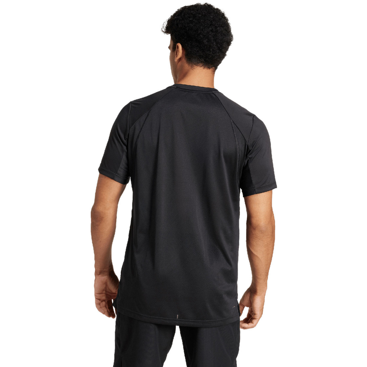 Back view of a model wearing the black adidas T-shirt.