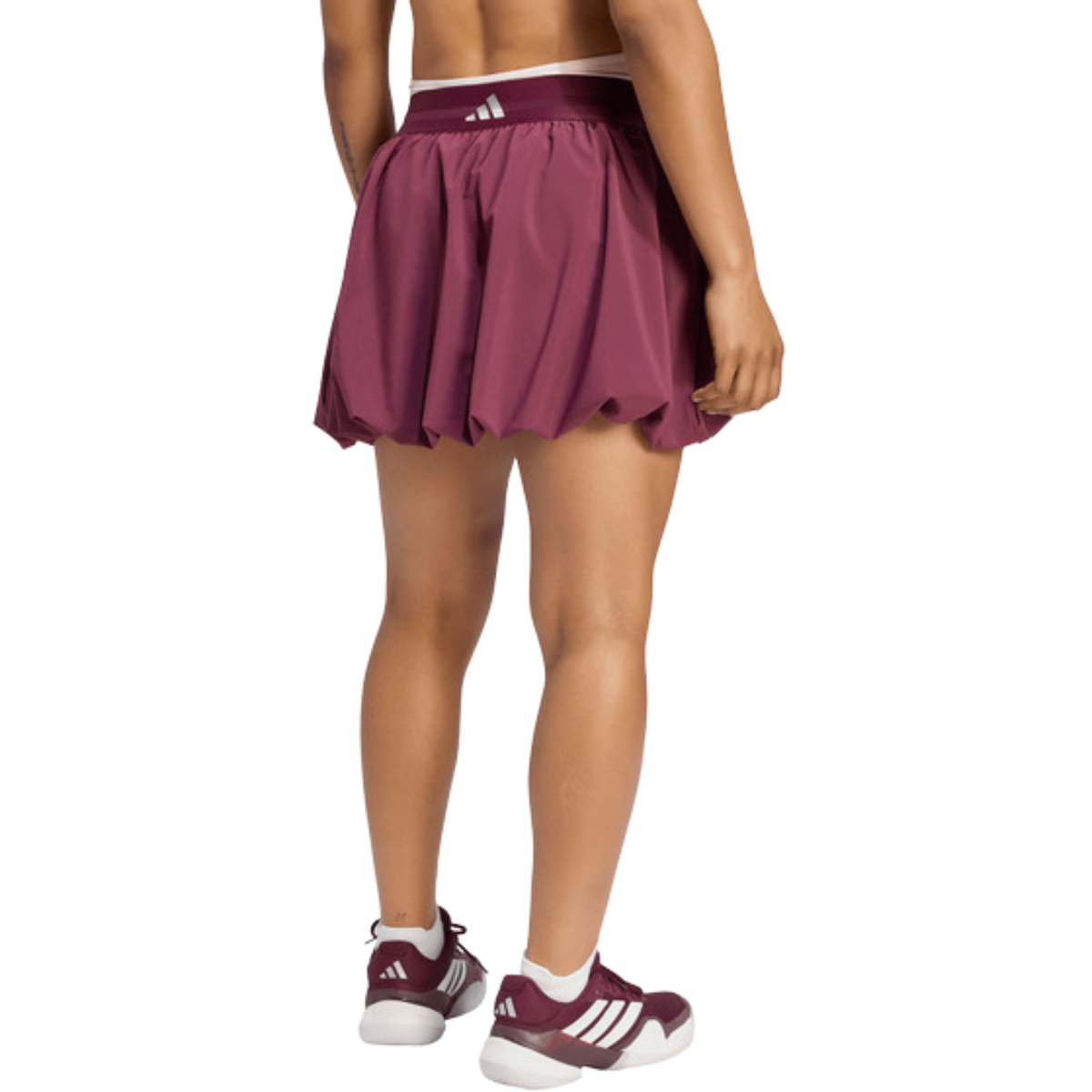 Back view of a model wearing the purple adidas women's skirt.
