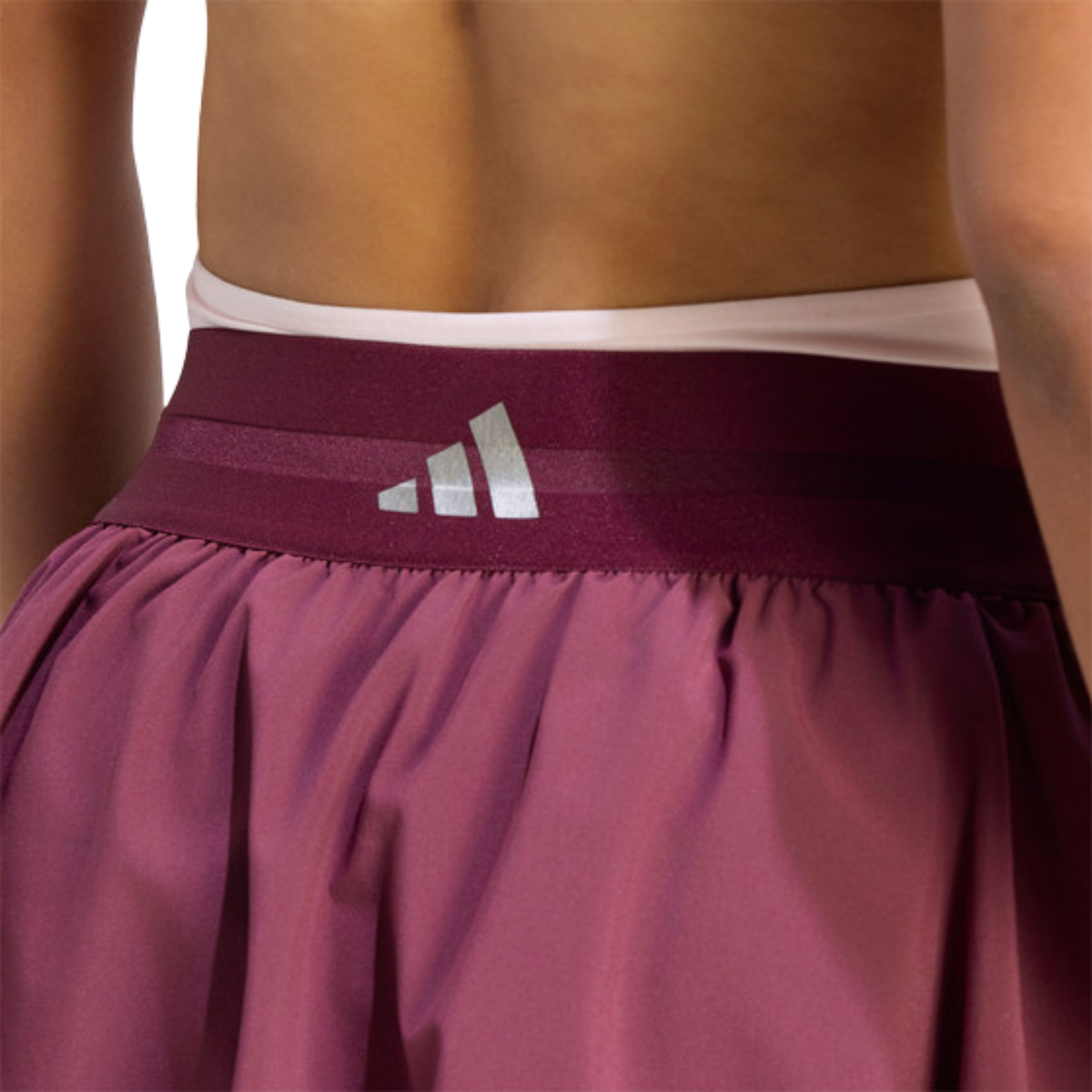 Close-up back view of the purple adidas women's skirt showing the waistband and adidas logo.