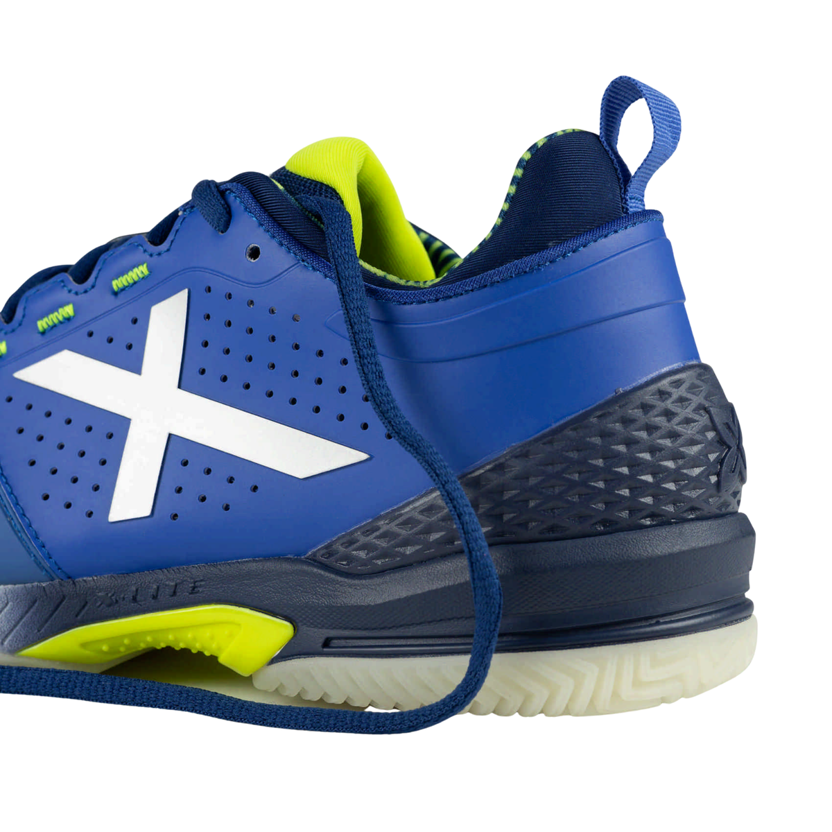 Close-up heel view of the Munich Atomik 56 padel shoe showing the blue upper, silver X logo, perforated side panels, fluorescent yellow lining, blue pull tab, dark blue textured heel support and white outsole.