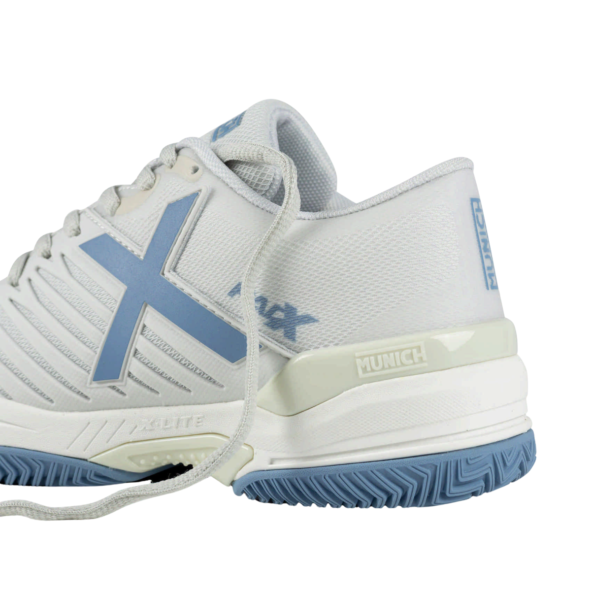 Close-up rear side view of the Munich PADX 69 padel shoe showing the white textured upper, light blue X logo, padded collar, cream heel support with Munich branding and blue herringbone outsole.