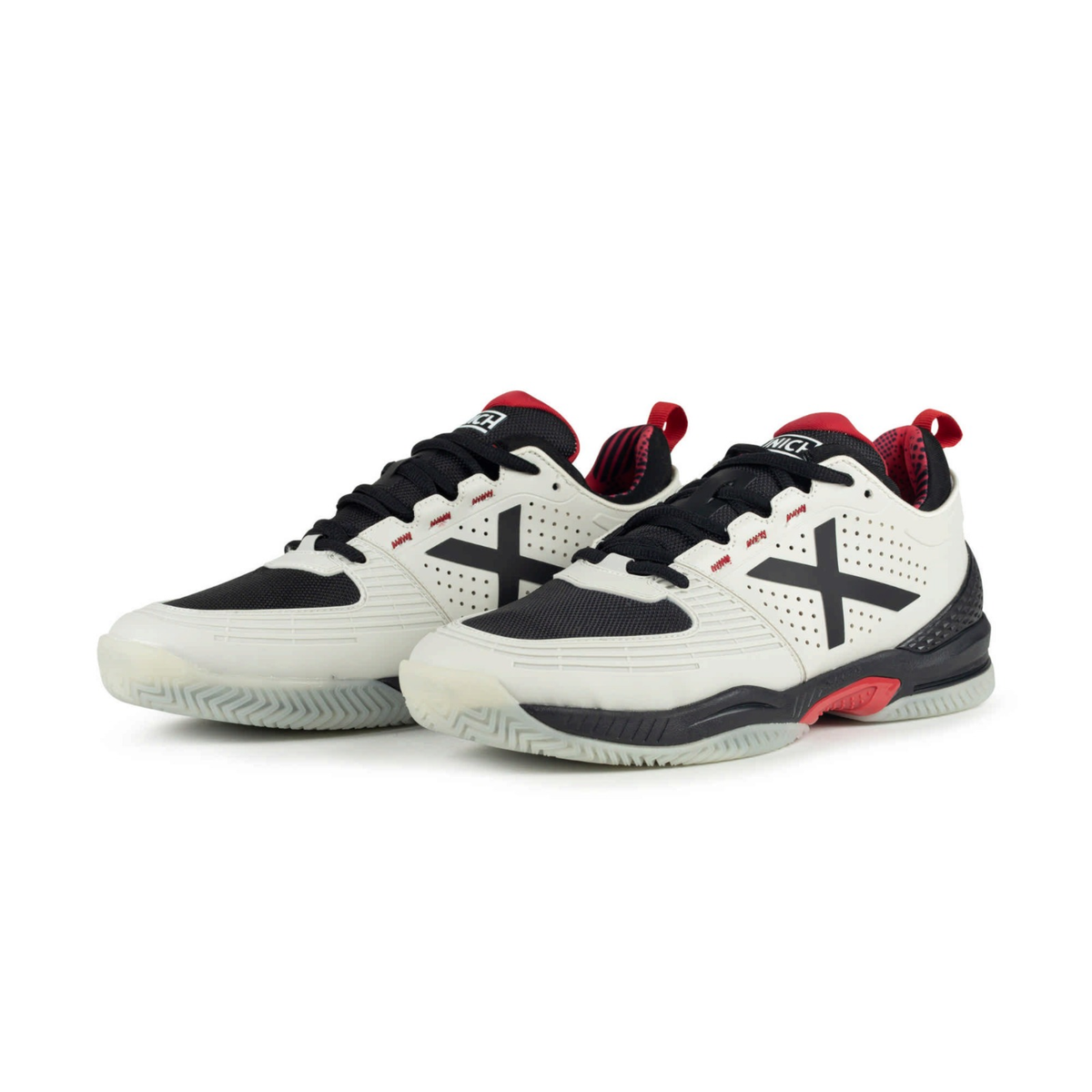 Pair of Munich Atomik 54 white padel shoes shown from a front angle with black laces, black X logos, red inner details, black heel sections and light outsoles.