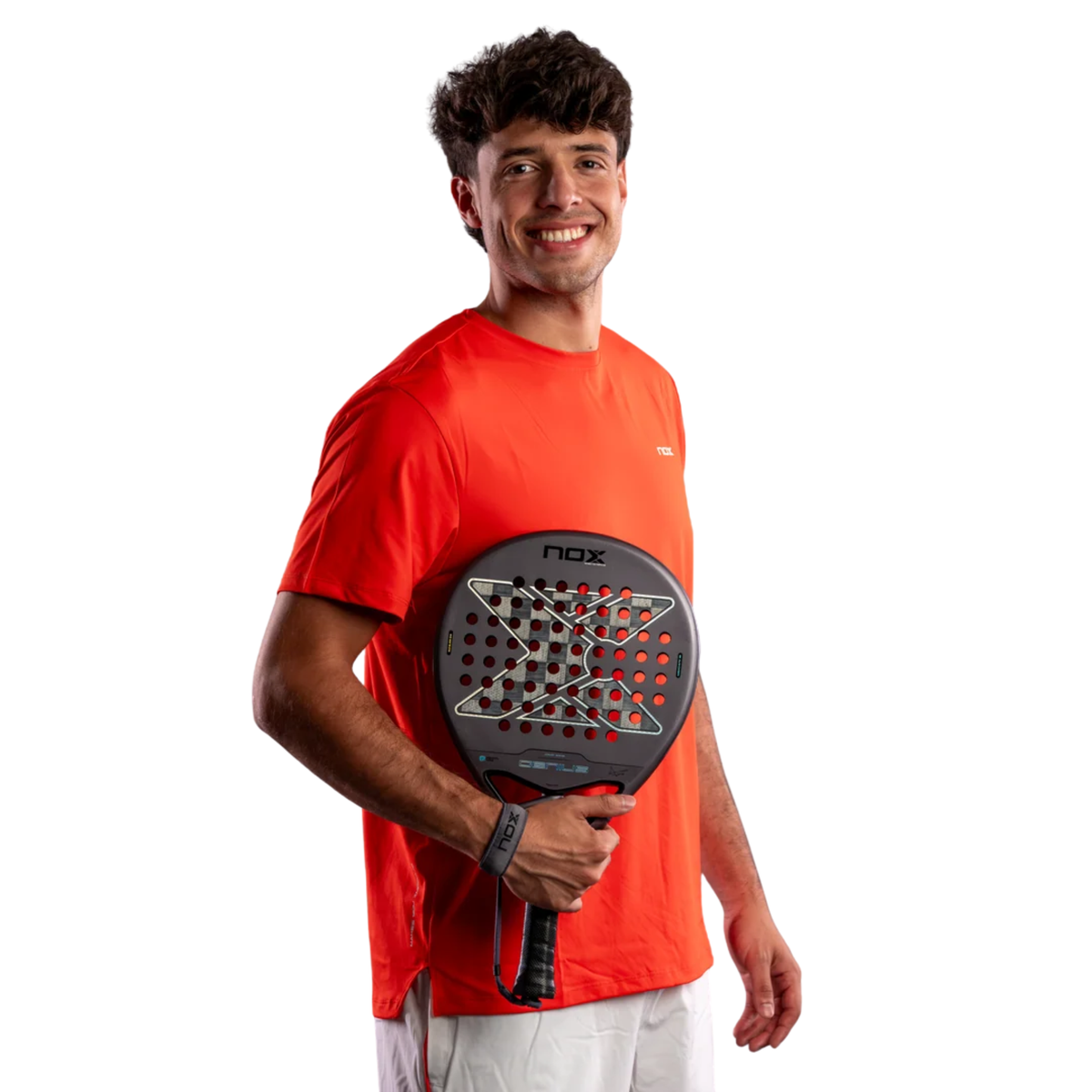 Professional padel player Agustín Tapia holding the Nox AT10 GENIUS 18K ALUM 2027 racket while wearing a red Nox shirt.