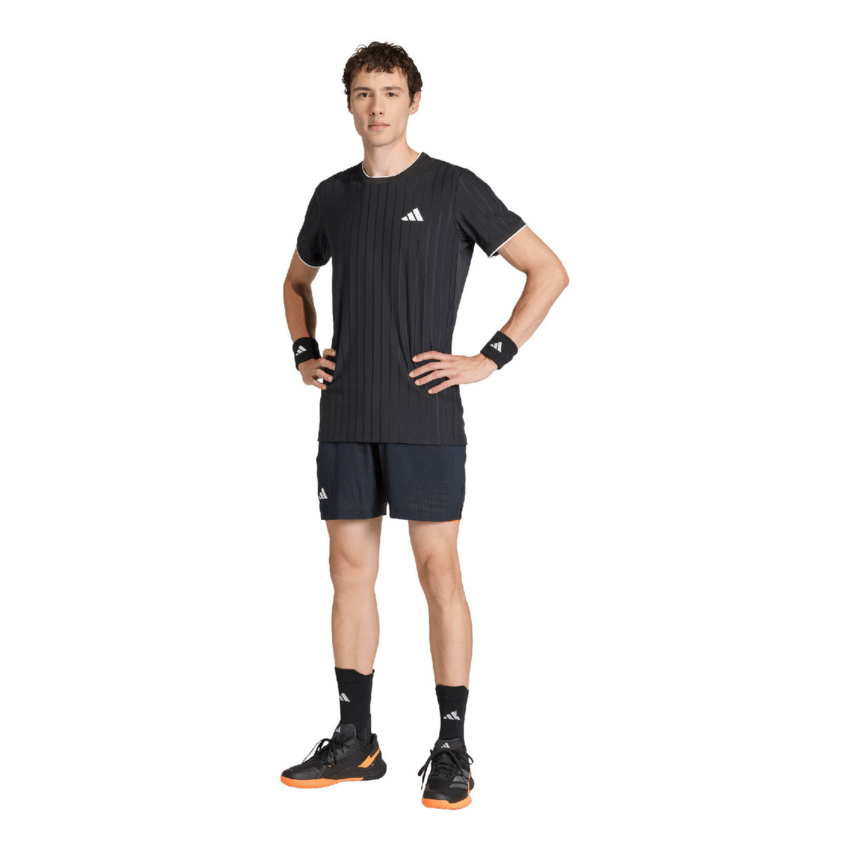 Full-body front view of a male model wearing the adidas Climacool Freelift Pro T-Shirt Black KG6053 with matching dark shorts, black wristbands and adidas padel shoes.