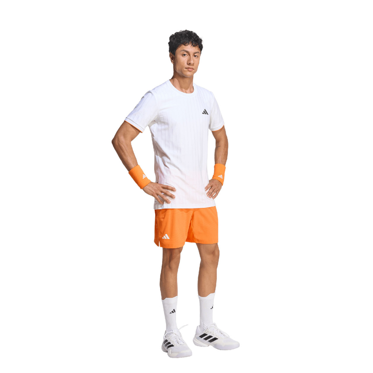 Full-body front view of a male model wearing the adidas Climacool Freelift Pro T-Shirt White with bright orange shorts, white crew socks, white adidas tennis shoes and orange wristbands.