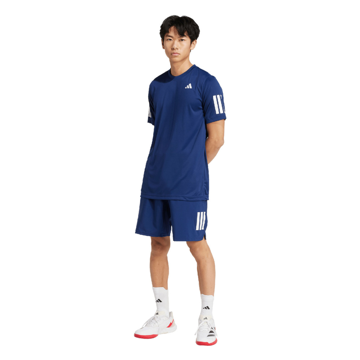 Full-body view of a male model wearing the adidas Club 3-Stripes Climacool T-Shirt Dark Blue with matching dark blue shorts and white sports shoes.