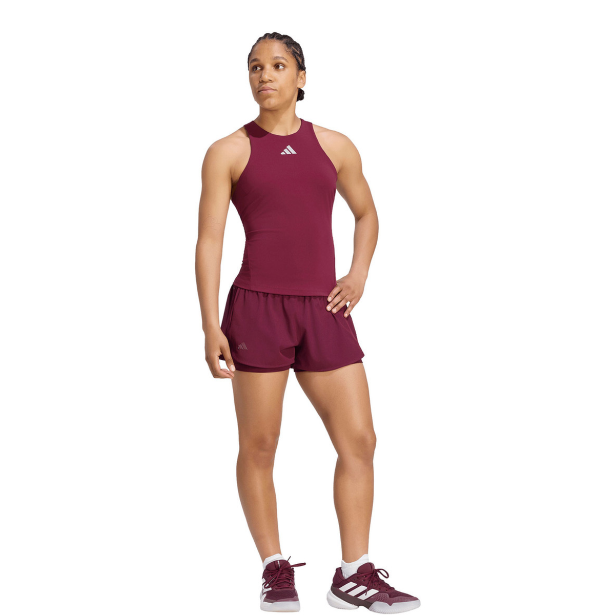 Full-body front view of a female model wearing the adidas Silver Y-Tank with matching burgundy adidas shorts and adidas sports shoes.