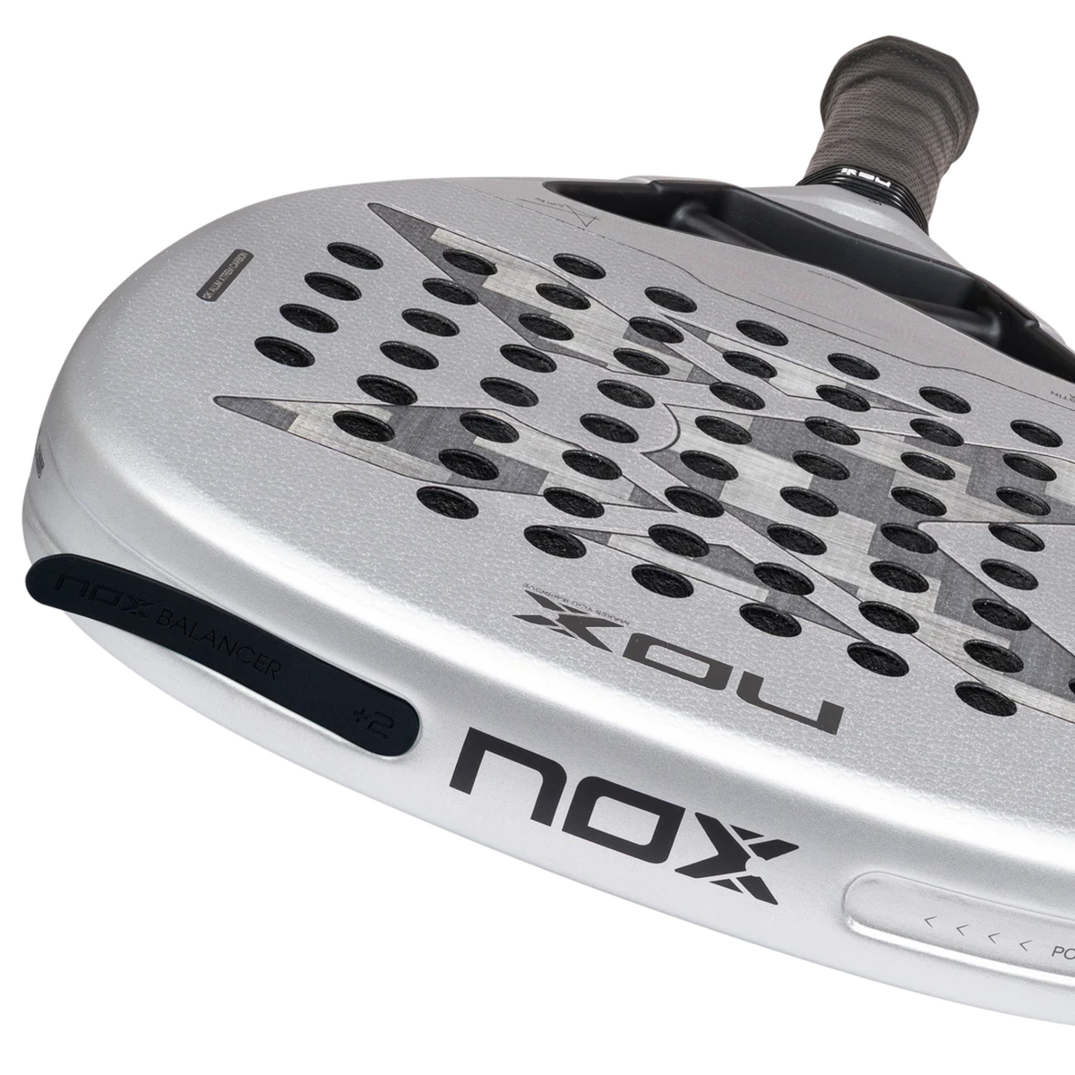 Close-up angled view of the NOX Genius Attack 12K Alum Xtrem Agustín Tapia 2027 padel racket, showing the white frame, perforated grey face, Nox side branding and side balance detail near the edge.