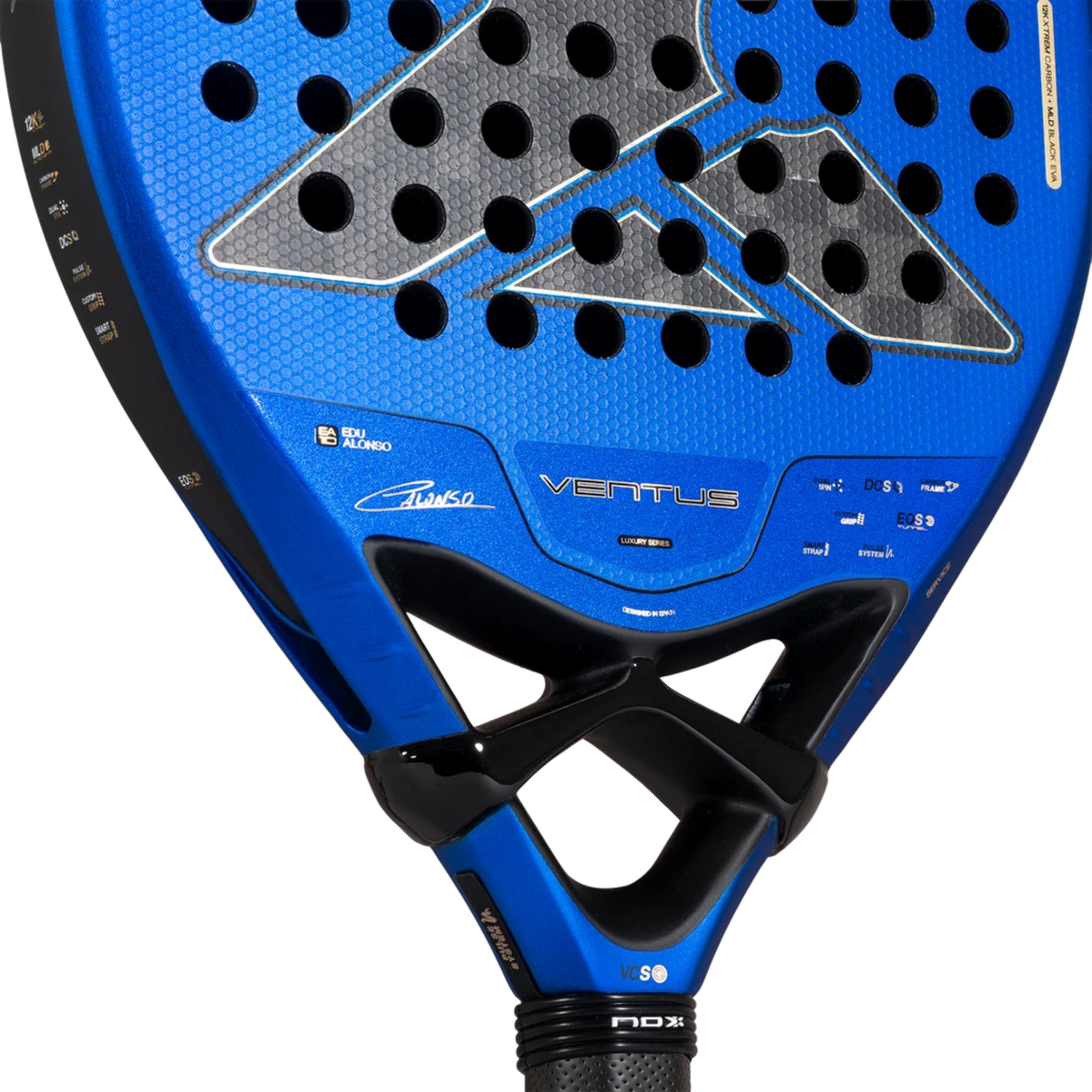 Close-up of the lower face of the NOX Ventus Hybrid 12K Xtrem Edu Alonso 2027, showing the metallic blue surface, perforated grey carbon-style pattern, Edu Alonso signature and printed product details.